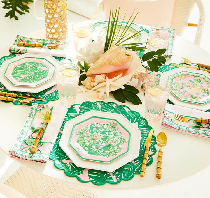 table set with pink and green lilly print dishes and place mats