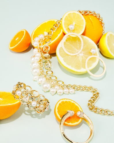 old and pearl jewelry on top of lemons