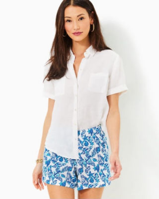 model wearing white linen top with blue and white printed bottoms