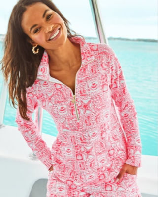 model wearing pink and white printed quarterzip top and bottoms on a boat