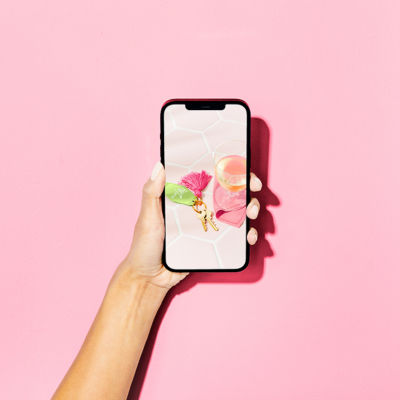 hand holding phone with club lilly key fob