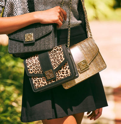 Woman holding 3 crossbody bags