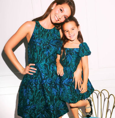 Woman and little girl wearing matching blue and brocade dresses