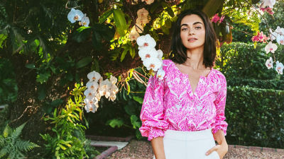 Woman wearing a pink printed top and white shorts