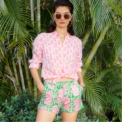 Woman wearing a pink and white printed linen top and printed shorts