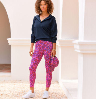 Woman wearing a navy sweatshirt with pink and navy printed leggings