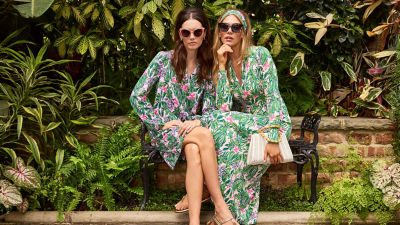 Two women wearing green and pink printed dresses