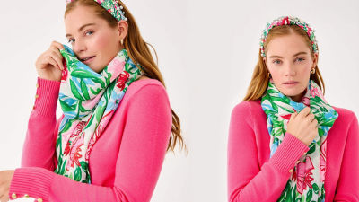 Woman wearing a green printed scarf and a pink sweater