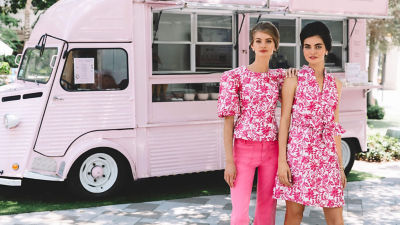 Two women wearing pink patterned outfits