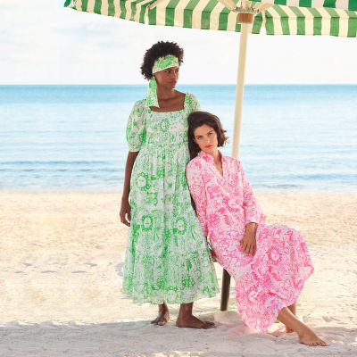Woman wearing a pink printed dress and another woman wearing a green printed dress