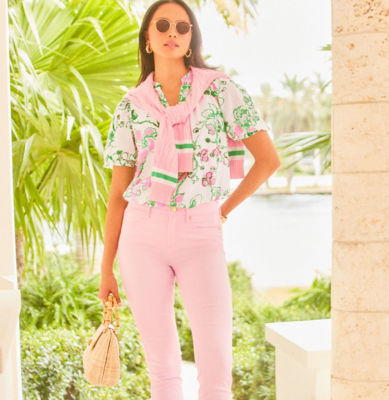 Woman wearing a printed top and pink jeans