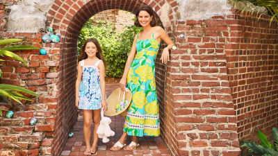 Woman wearing a long yellow and blue printed dress and a girl wearing a blue printed dress