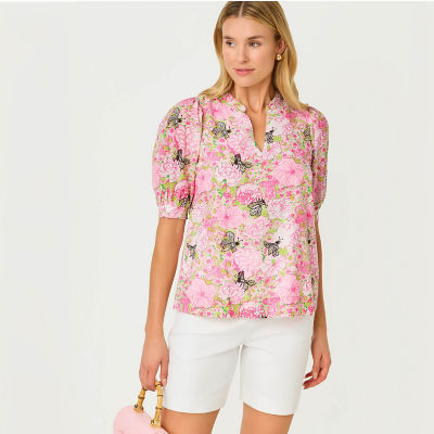 Woman wearing a pink printed top and white shorts