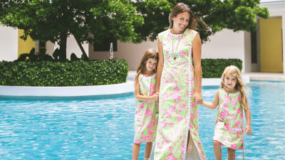 Woman and little girls wearing green and pink printed dresses