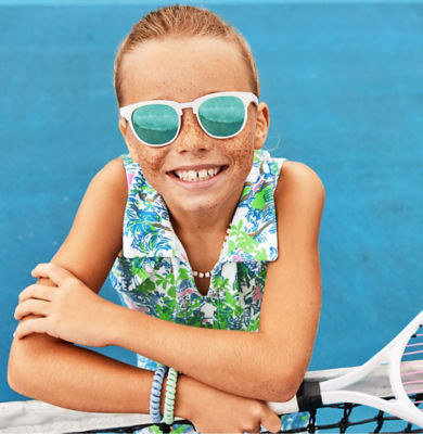 Little girl wearing sunglasses on tennis court