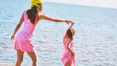 Woman and little girl wearing matching pink dresses