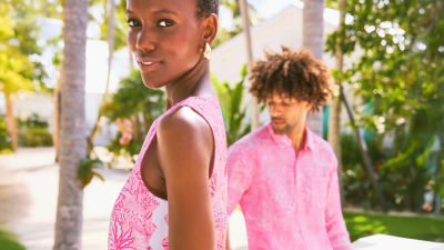 Woman and little girl wearing matching pink and red printed swimwear