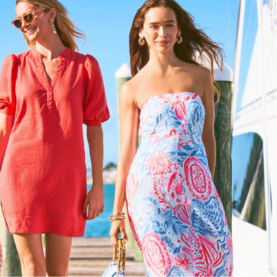 Woman wearing a red dress and another women wearing a red white and blue printed dress