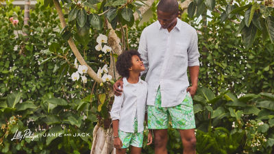 Man and little boy wearing white shirts and green printed shorts